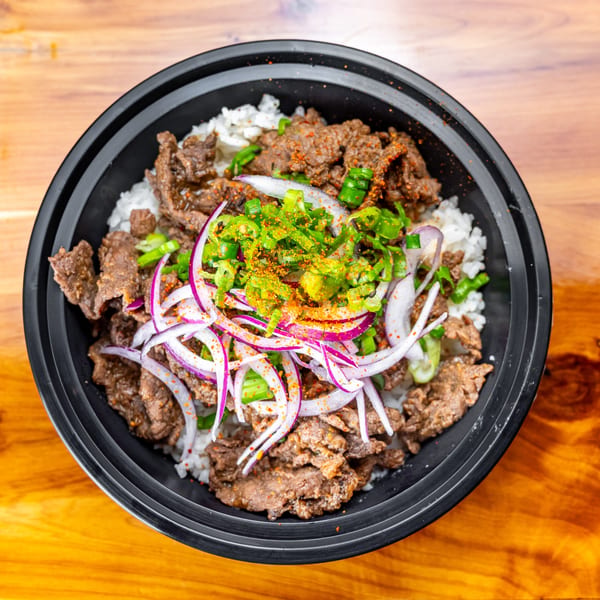 Pokefit's Asian-fusion beef bowl with rice, red onions, green onions, and spices.